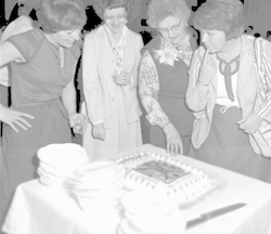 Juanita Mogardo with guests admiring the cake.