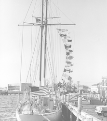 Aries at dock, flags flying