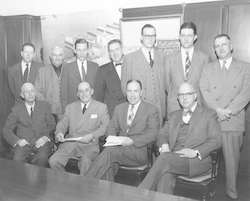 Group together posing during unidentified meeting.