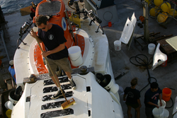 Gavin Eppard washes Alvin's topside on deck of Atlantis.
