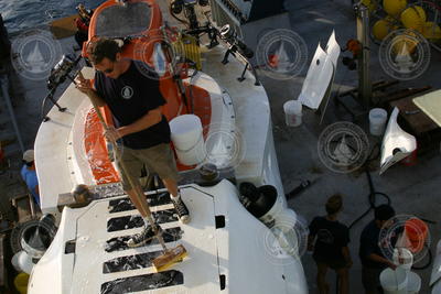 Gavin Eppard washes Alvin's topside on deck of Atlantis.