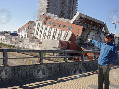 Jian Lin pointing to a bulding in Concepcion damaged by Chile earthquake.