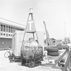 Recovered buoy on dock, with barnacles and other fouling covering the underside.