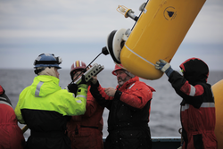 Kjetil Vaage and Jim Ryder (center) remove a MicroCat from a mooring line.