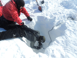 Researchers burying seismic sensors deep in the snow at Ross Ice Shelf.