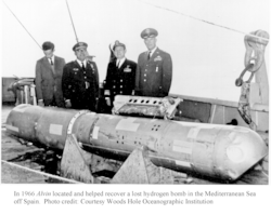 Navy officials posing with the hydrogen bomb recovered using DSV Alvin.
