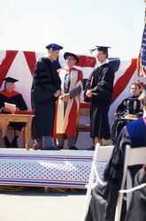 Graduates receiving diplomas and congratulations.