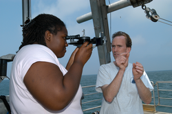 Ken Houtler teaching DeAnna McCadney how to use a sextant to navigate.