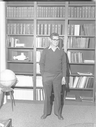 John Steele standing in front of bookcase