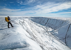 Laura Stevens overlooks a canyon carved by a glacial river system in Greenland.