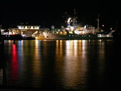 R/V Oceanus, R/V Endeavor and the R/V Knorr at the WHOI dock at night.