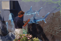 Paul Oberlander painting oceanic mural on Exhibit Center.
