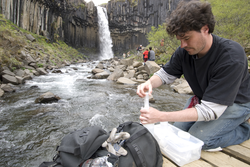 Christian Miller water sampling a stream in Iceland.