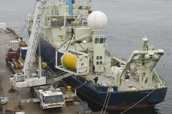 Long core rope storage drum being loaded onto R/V Knorr.