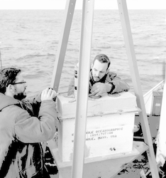 Two unidentified men working with buoy (?) on deck